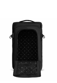 Mochila de viaje rectangular negra con asa superior, compartimento frontal con cremallera abierto que revela un bolsillo de malla y forro interior con marca.