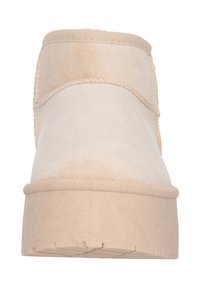 Botín beige con parte superior de suave ante, puntera redonda y suela de goma. Presenta un detalle de costura a lo largo del eje y textura acanalada en la suela.