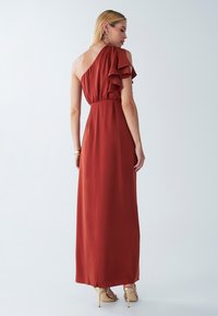 Maximeks dressi poltunud oranžis, valmistatud kergest kangast. Üks õlg, millel on ruffle detail ning elastse vöökoht. Sile viimistlus.