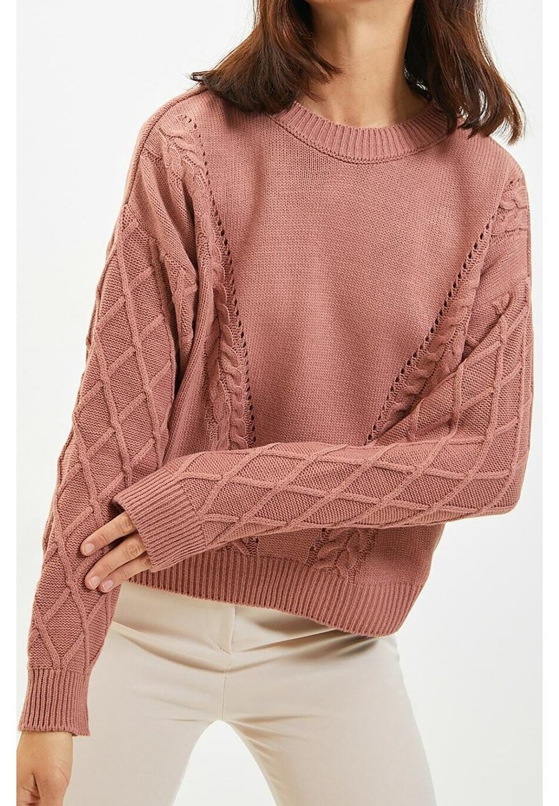 Gestrickter Pullover in Staubrosa, mit einem gerippten Rundhalsausschnitt und strukturierten Ärmeln mit Diamantmuster. Lockerer Schnitt mit verlängerten Bündchen.