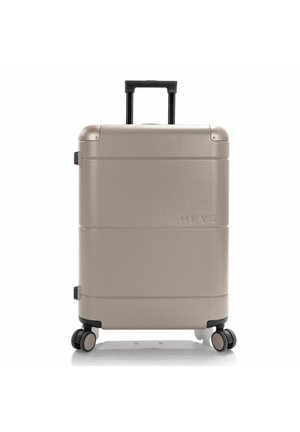 Hartschalentrolley in metallischem Gold mit strukturiertem Finish, ausgestattet mit einem ausziehbaren schwarzen Griff und vier Rollen für Mobilität.