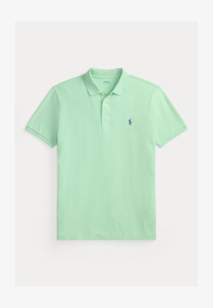 Šviesiai žalia polo marškinėliai, pagaminti iš lygaus medvilnės audinio, su dviem sagomis ir mažu mėlynu išsiuvinėtu logotipu ant krūtinės.