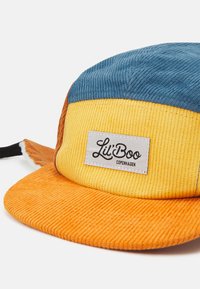 Casquette en velours côtelé avec des panneaux bleus, jaunes et oranges. Comprend une étiquette rectangulaire avec "Lil' Boo Copenhagen" en texte noir sur le devant.