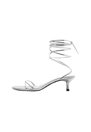 Sandalia plateada con tiras, tacón bajo tipo kitten y largas tiras que envuelven el tobillo, con un diseño elegante y minimalista.
