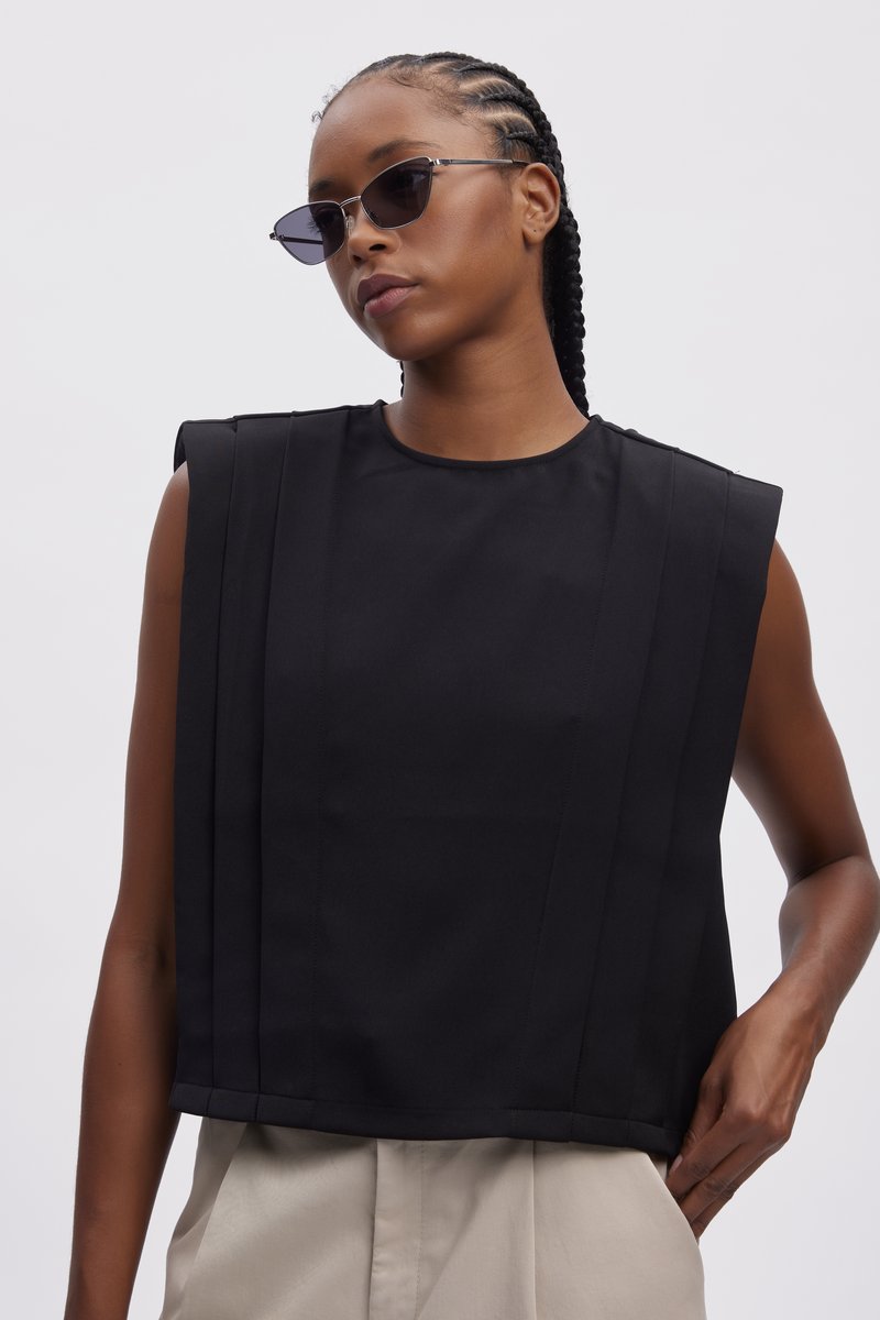 Sort cropped top med strukturerede skuldre, der har lodrette plisseringer og en rund halsudskæring. Glat stof med en mat overflade.
