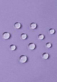 Jasne, okrągłe krople na teksturowanym fioletowym tle. Krople różnią się rozmiarem, ukazując odbicia światła oraz heksagonalny wzór pod spodem.