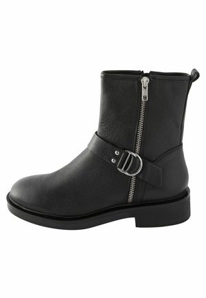 Bottine noire en cuir avec fermeture éclair latérale et bride décorative avec boucle argentée, talon bas et languette à l'arrière.