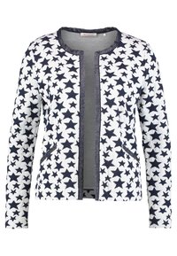 Witte cardigan met marineblauw sterpatroon, open voorkant, lange mouwen en gestructureerde stof. Voorzien van twee zakken aan de voorkant en een ronde halslijn.