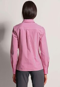 Rood-wit gestreepte shirt met een klassieke kraag, lange mouwen en een aansluitend ontwerp aan de achterkant met subtiele plooien op de schouders.