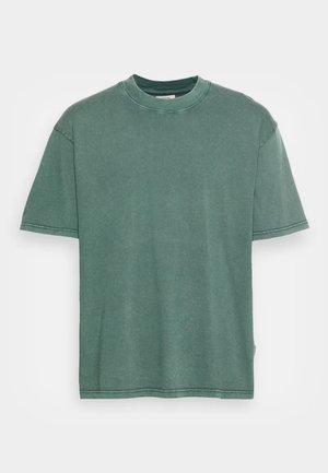 T-shirt vert en coton à manches courtes, col rond, et coupe décontractée. Présente une texture légèrement décolorée et des coutures visibles le long des bords.