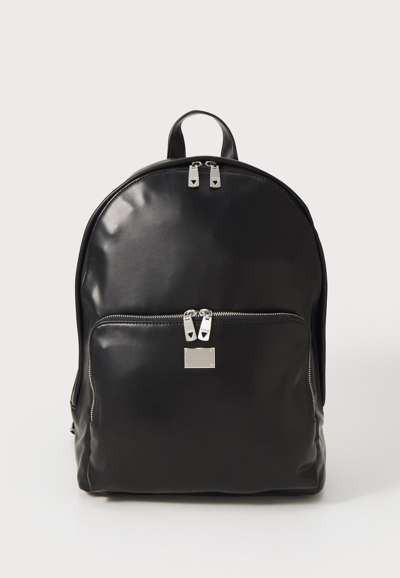 Zaino in pelle nera con una consistenza liscia, forma arrotondata, tasca con zip anteriore e dettagli in metallo argentato. Presenta doppie zip superiori.