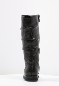 Botte en cuir noir haute jusqu'au genou avec un design légèrement froissé, fermeture éclair à l'arrière et un petit talon empilé. Texture lisse et sans motifs visibles.