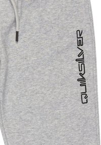 Lichtgrijze sweatpants van zachte stof met een trekkoord. Kenmerkt zich door een vetgedrukt zwart "Quiksilver" logo dat langs de zijkant is gedrukt.