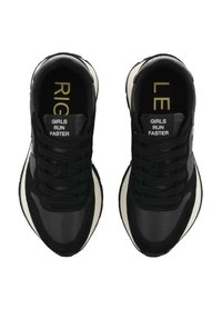 Een paar zwart-witte sneakers met de tekst "GIRLS RUN FASTER" op de tong, en "RIGHT" en "LEFT" binnenin elke schoen respectievelijk.