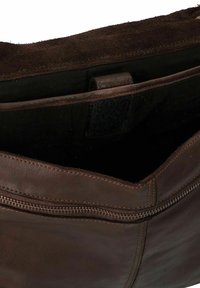 Bolso de cuero marrón con una textura suave, con cierre de cremallera y un compartimento interior. La costura es visible a lo largo de los bordes.