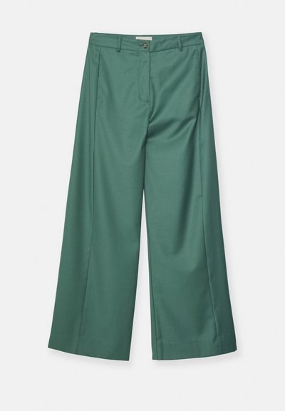 Pantaloni a gamba larga di colore teal, realizzati in un tessuto morbido. Presentano una chiusura con bottone anteriore e due tasche laterali.