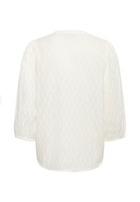 Blouse blanche à manches longues avec un motif texturé subtil, encolure arrondie et manches légèrement bouffantes, vue de dos sur un fond uni.