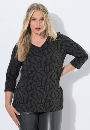 Top noir à col en V avec un motif géométrique répétitif en gris foncé. Manches trois-quarts et texture de tissu lisse.