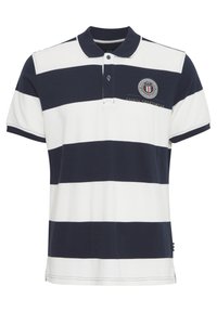 Polo tričko pruhované v námorníckej modrej a bielej farbe, vyrobené z bavlnenej látky. Má golier na gombíky a vyšívané logo na hrudi. Krátke rukávy.