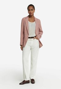 Ljusrosa linnekavaj i kombination med en vit blus och krämfärgade byxor. Brunt bälte och mörkbruna loafers fulländar outfiten.