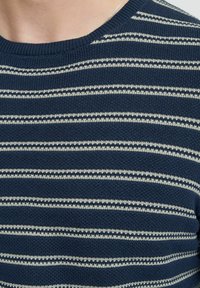 Maglione lavorato a maglia blu navy con strisce bianche orizzontali, scollo rotondo e tessuto testurizzato, dal fit rilassato.