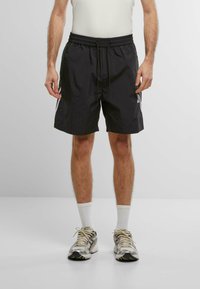 Sorte sportsshorts med elastisk talje og snor. Længde over knæet, lavet af let material, med sidelommer.