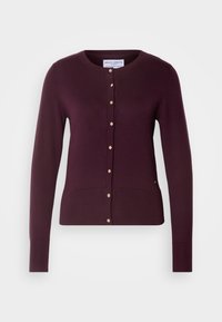 Cardigan en maille violet foncé à manches longues avec col rond et une rangée de petits boutons clairs à l'avant.