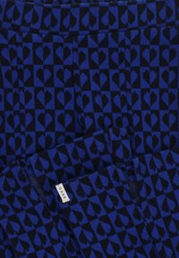 BlauwPatronenstof met afwisselend donkere en lichtere blauwe hartvormen op een marineblauwe achtergrond. Label leest "LOOXS." Gelaagde gebreide afwerking.