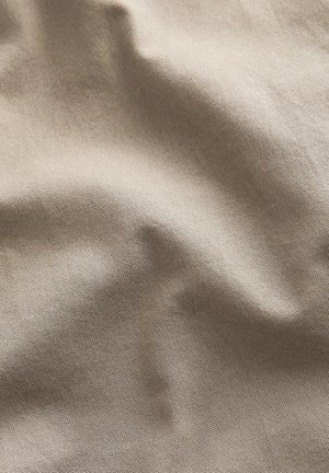 Tissu beige texturé avec une surface lisse, présentant des plis et des froissements subtils, léger et avec une qualité de drapés.