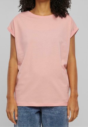 Jasnoróżowy, krótki rękaw, bawełniany T-shirt z podwiniętymi mankietami i okrągłym dekoltem, w połączeniu z niebieskimi dżinsami. Prosty design, jednolity kolor.