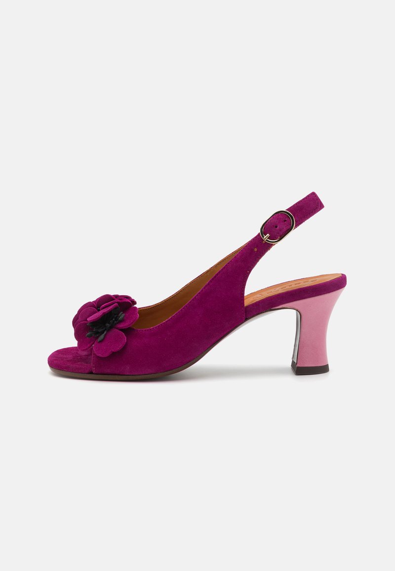 Magenta ruskinds slingback sko med åben tå, prydet med en blomsterdetalje og en tofarvet pink hæl. Justerbar rem med metalspænde.