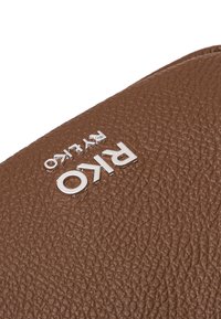 Borsa in pelle marrone con texture, caratterizzata da un logo "Riko" in argento, vista ravvicinata che mette in risalto i dettagli del materiale e della finitura.