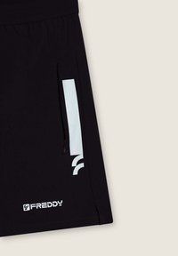 Shorts sportivi neri con tasca con zip, strisce bianche a contrasto e logo "FREDDY" vicino all'orlo. Tessuto liscio e leggero.