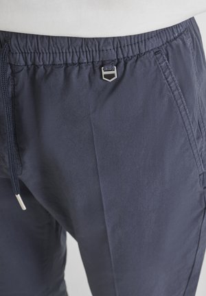 Pantaloni con vita elasticizzata blu navy, tasche frontali, coulisse e piccolo dettaglio decorativo in metallo argento al centro della vita.