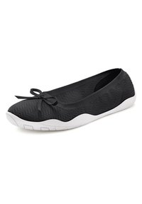 Scarpa piatta nera con tomaia in rete testurizzata, suola in gomma bianca e dettaglio a fiocco sulla punta. Il design include una leggera curva sul tallone.