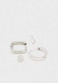 Ensemble de boucles d'oreilles en métal argenté comprenant une bague carrée, une créole arrondie et deux accents géométriques ; texture lisse avec une finition polie.