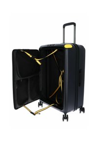 Valise rigide noire avec des accents jaunes, double roues, poignée rétractable et compartiments intérieurs noirs sécurisés par des sangles.
