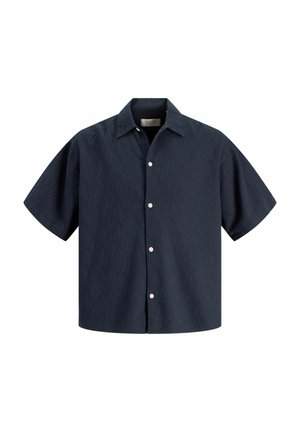 Chemise bleu marine foncé à manches courtes boutonnée, col pointu, avec des boutons blancs sur le devant et un ourlet droit.