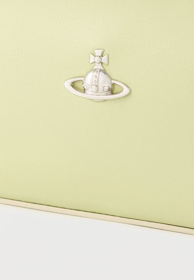 Φωτεινό πράσινο δέρμα με υφή, με ασημένιο έμβλημα κορώνας και δαχτυλιδιού. Στο κάτω μέρος υπάρχει λεπτομέρεια λευκής αντίθεσης.