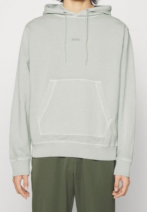 Ljust grön sweatshirt med huva, framficka och ribbad muddar. Har en diskret "BOSS"-logotyp i mitten. Mjuk tygtextur.
