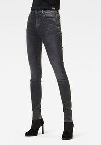 Jeans ajustados en denim gris oscuro con un acabado descolorido, que presentan un diseño clásico de cinco bolsillos y detalles de costura sutiles a lo largo de los lados.