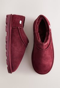 Stivaletti alla caviglia in camoscio color bordeaux con punta tonda, fodera interna soffice, cuciture rinforzate e suola in gomma texturizzata per una migliore aderenza.