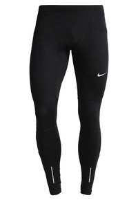 Leggings de sport noirs en matériau extensible. Dotés d'un petit logo Nike blanc et d'accents réfléchissants sur le bas des jambes.