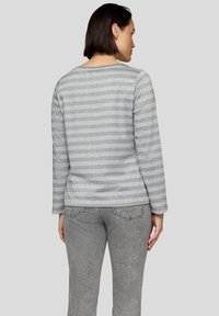 Grau langärmliges Oberteil mit hellgrauen horizontalen Streifen, Rundhals-Ausschnitt und weicher Textur, kombiniert mit grauen Jeans mit Gesäßtaschen.