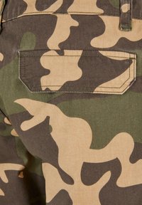 Camouflage cargo shorts med et flerfarget mønster i grønne nyanser og brunt. Detaljer inkluderer en baklomme med firkantet klaff. Slitesterkt stoff.