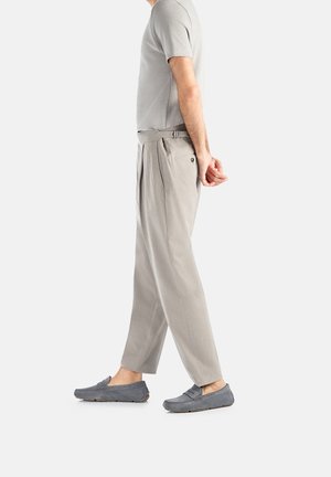 Lys grå kortærmet skjorte, lys grå plisserede bukser med bælte, og grå ruskinds loafers med gummisåler, vist fra siden.