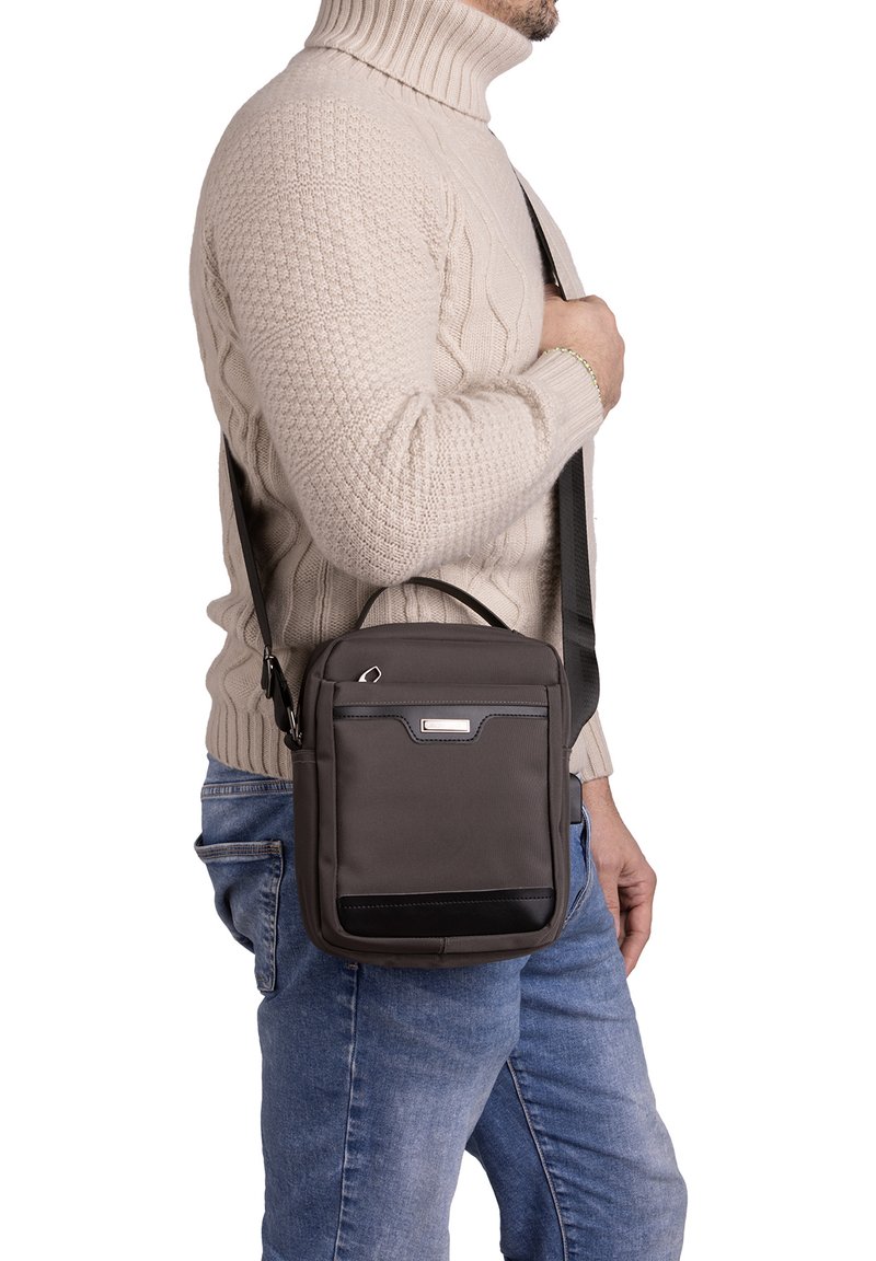 Borsa a spalla grigia con superficie texture, manico superiore e tracolla regolabile, dotata di una tasca frontale e un elegante accento nero.