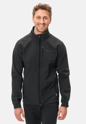 Veste softshell noire avec col montant, fermeture éclair sur le devant et poches latérales. Présente un logo sur la poitrine. Tissu texturé et résistant à l'eau.