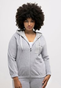 Grauer Reißverschluss-Hoodie mit einer hellgrauen Kapuze, Kordeln und einer Vorderasche. Verfügt über lange Ärmel und eine lockere Passform. Weicher, strukturiert Stoff.
