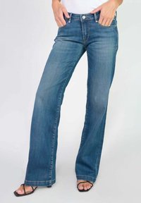 Jean en denim bleu clair, évasé, avec une conception à cinq poches, fermeture à bouton et lavage moyen. Texture lisse et coupe droite de la genou à l'ourlet.